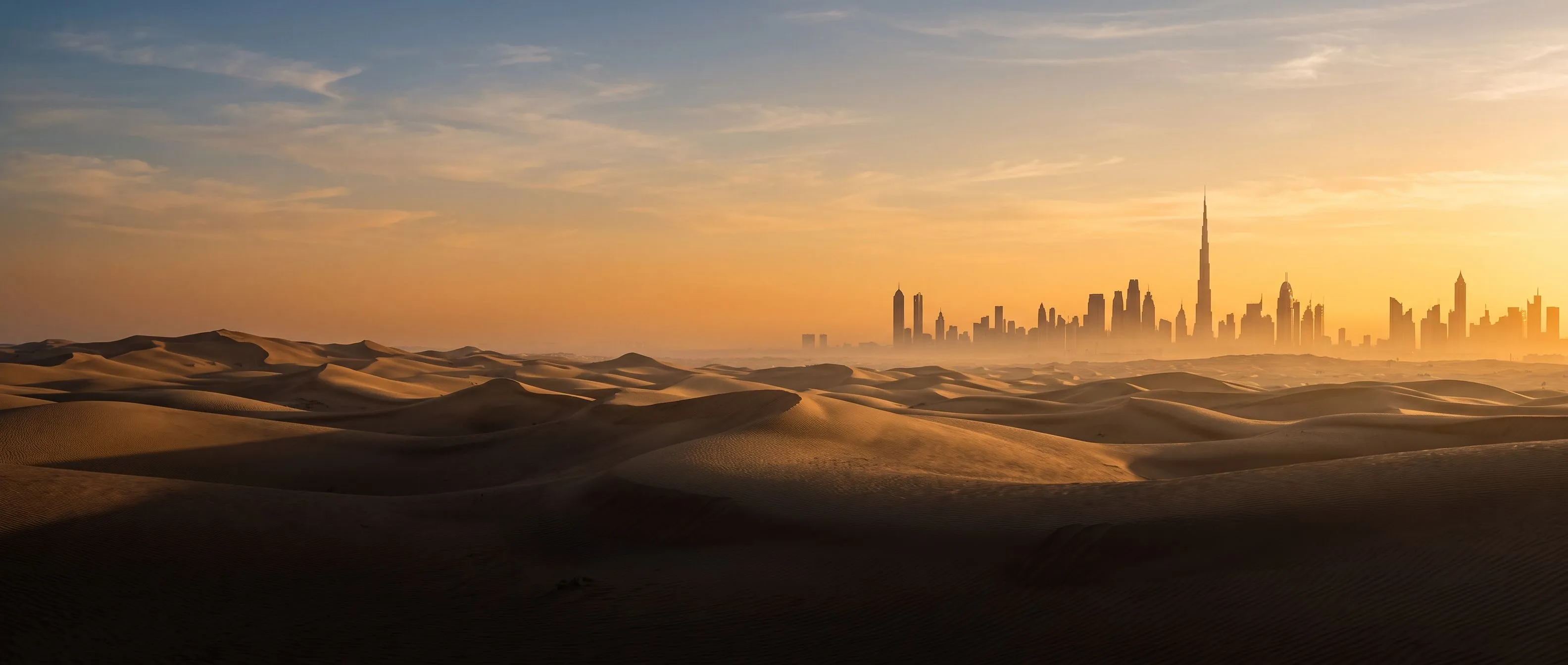 Pustynne wydmy spotykające panoramę Dubaju o wschodzie słońca